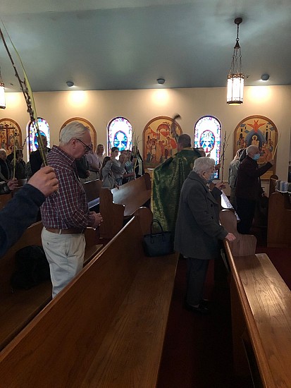 With parishioners holding branches of palms and pussy-willows high, Fr. Sergei blesses the palms and parishioners